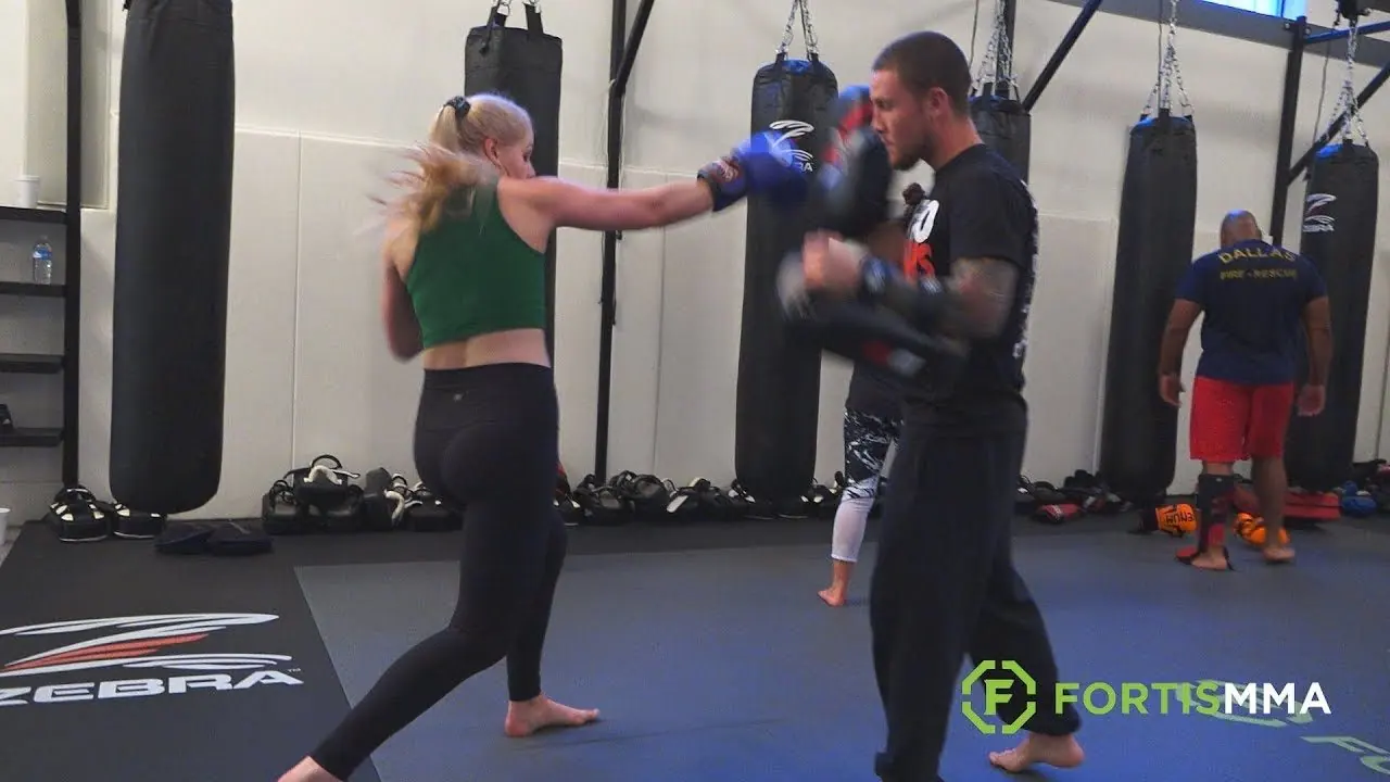 A Fortis member hitting pads with a coach